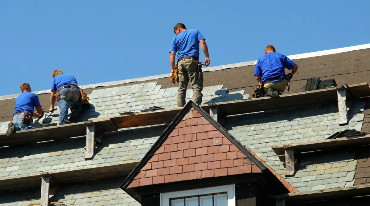 Roof replacement in progress with a team of professional contractors installing new shingles on a residential home in Ann Arbor, Mi